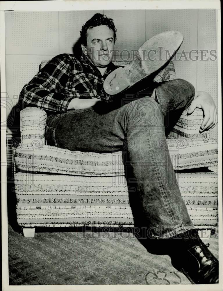 1957 Press Photo Jim Arness, actor, shows his size 12 shoes. - kfx36161- Historic Images