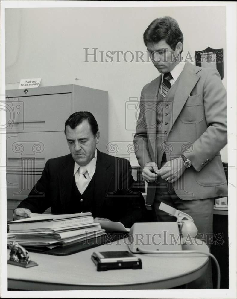 1978 Press Photo Ron Poindexter looks on as Tampa police officer reads document- Historic Images