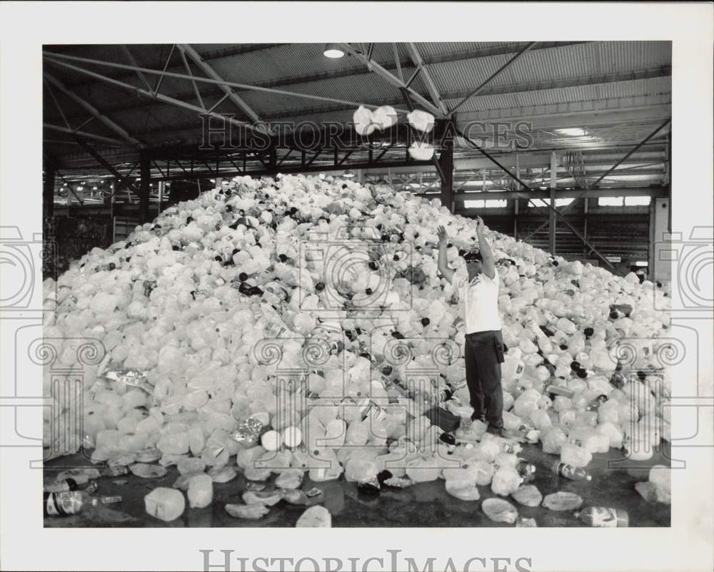 1990 Press Photo Gerry Snell tosses plastic bottles at Materials Recovery Center- Historic Images