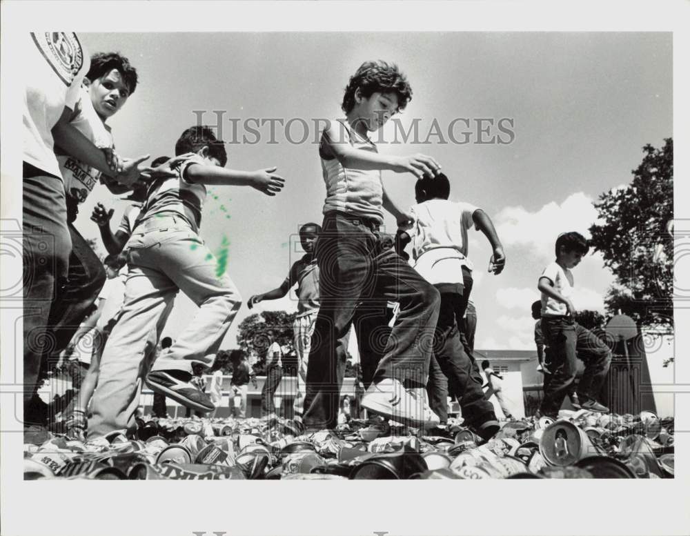 1985 Press Photo Children crushing empty aluminum cans - lra43460- Historic Images