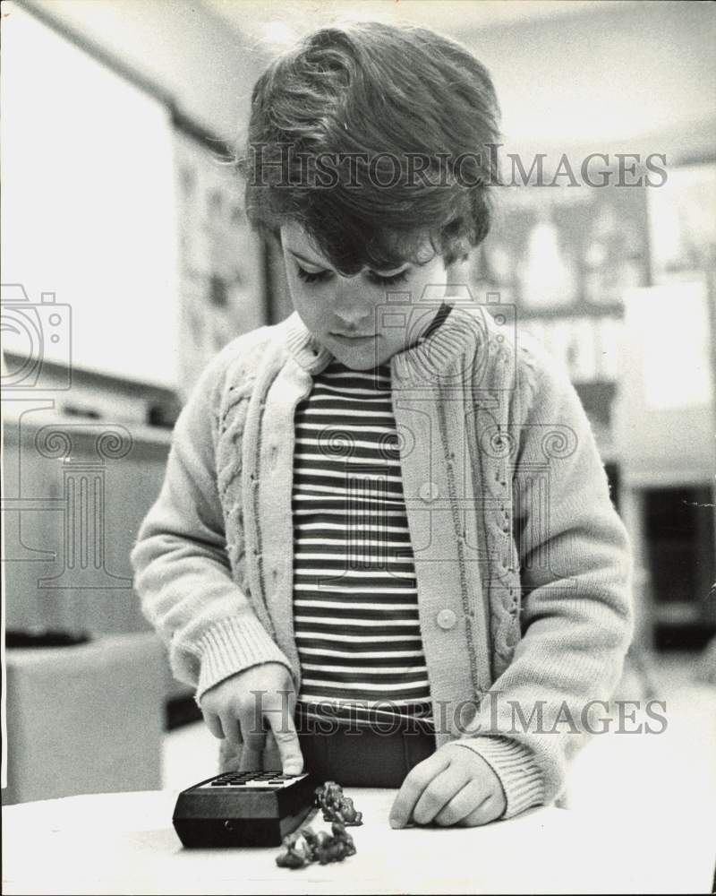 1975 Press Photo Kelly Farnsworth counts with calculator and frogs - lra65600- Historic Images