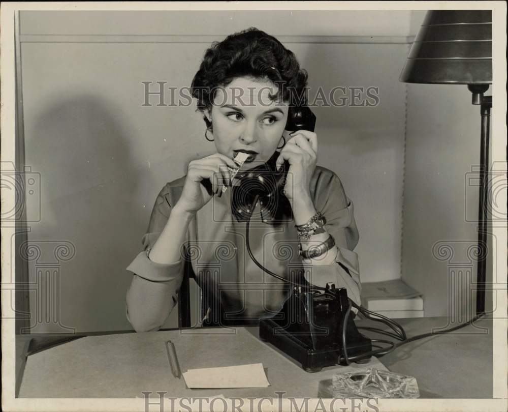 1954 Press Photo Woman chews gum and talks on phone at office - lra71814- Historic Images