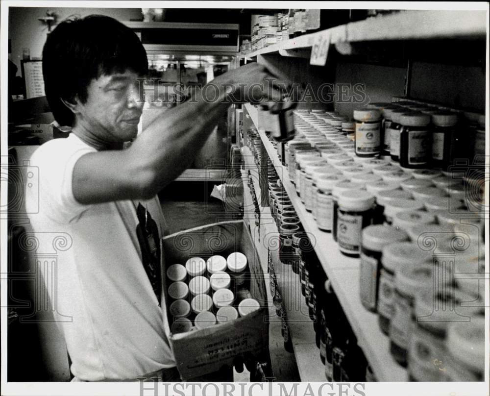 1982 Press Photo Pong Luevitool stocks supplies at the Thai Center in Hialeah- Historic Images