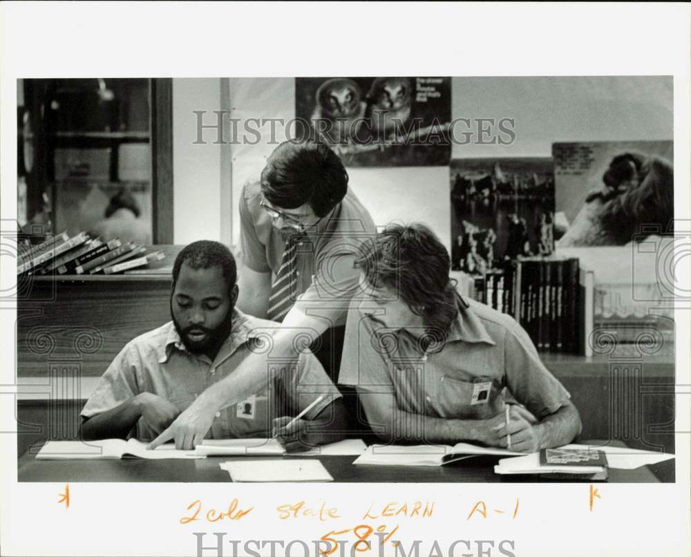 1983 Press Photo Inmates work on English during class as John Stuckey looks on- Historic Images