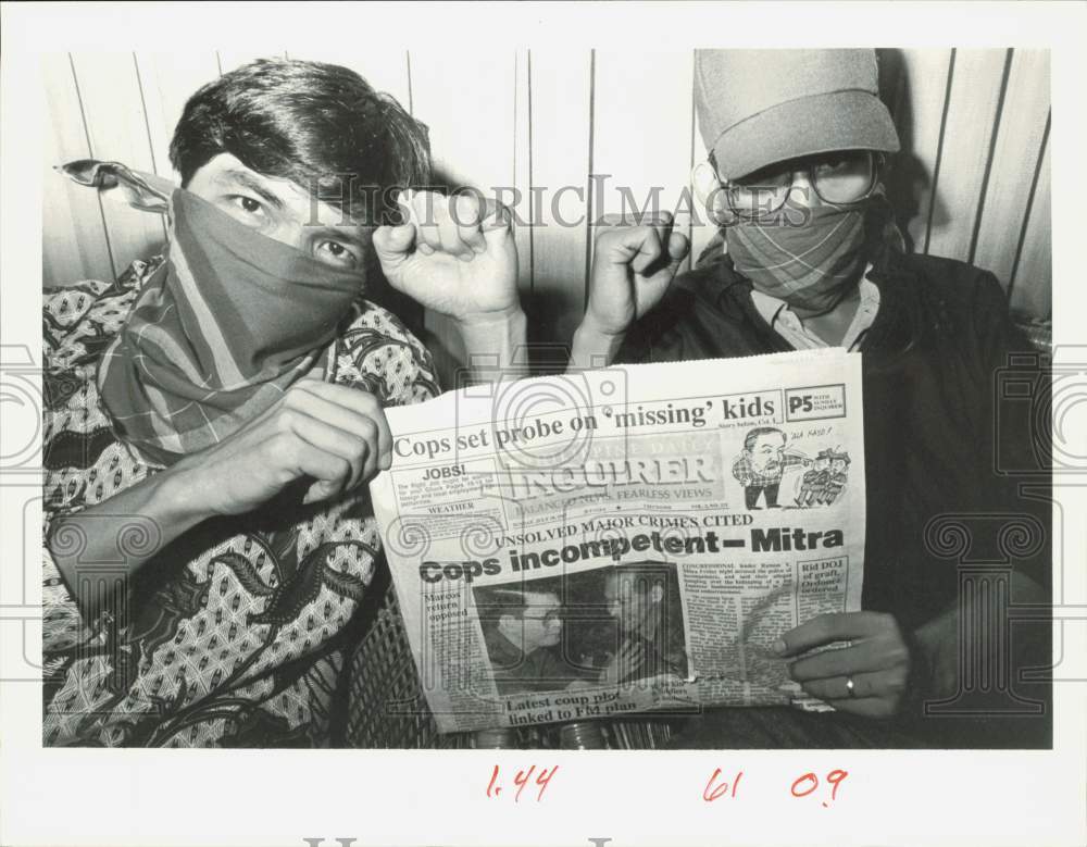 1987 Press Photo Men with face covered by handkerchiefs holding a newspaper- Historic Images