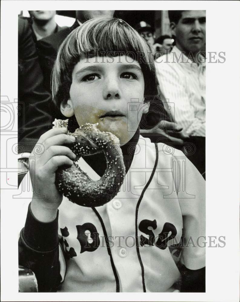 1987 Press Photo Little Aaron Kaufman eating pretzel during Red Sox Game- Historic Images