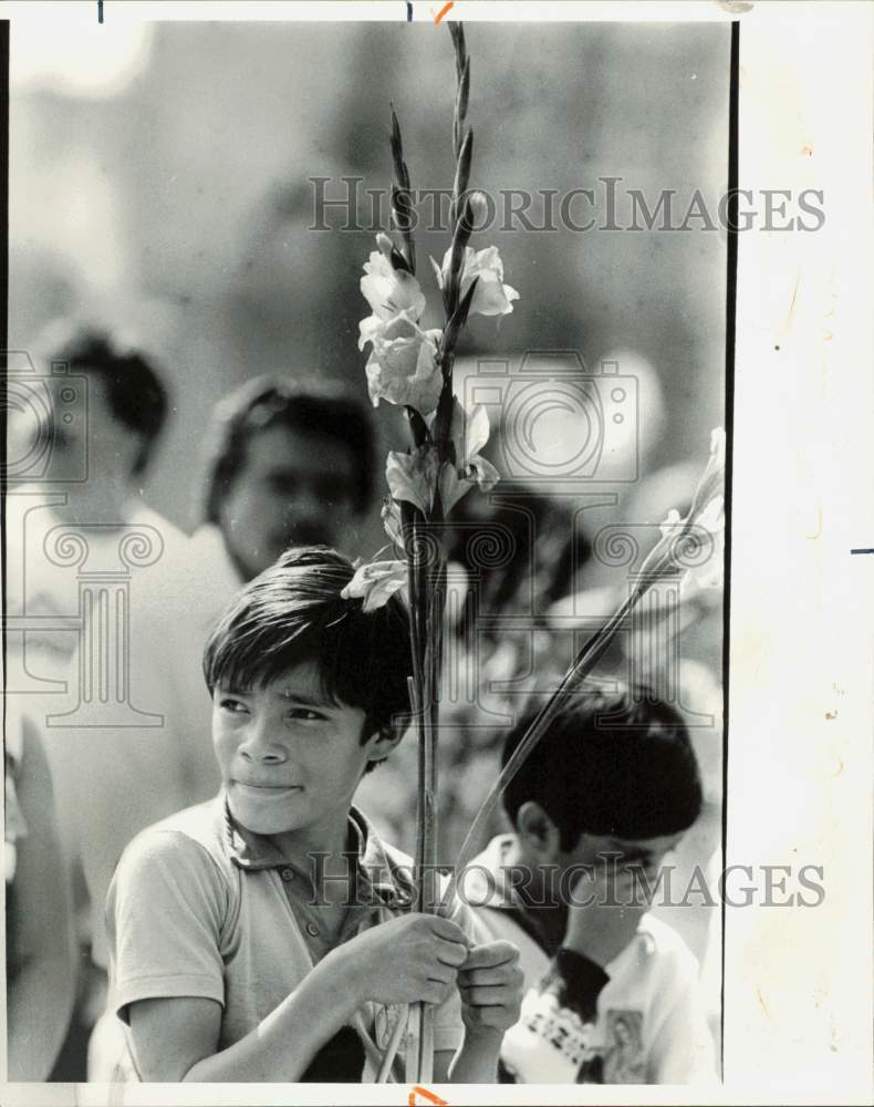 1985 Press Photo A Mexican child holding flower during early mass for the dead- Historic Images