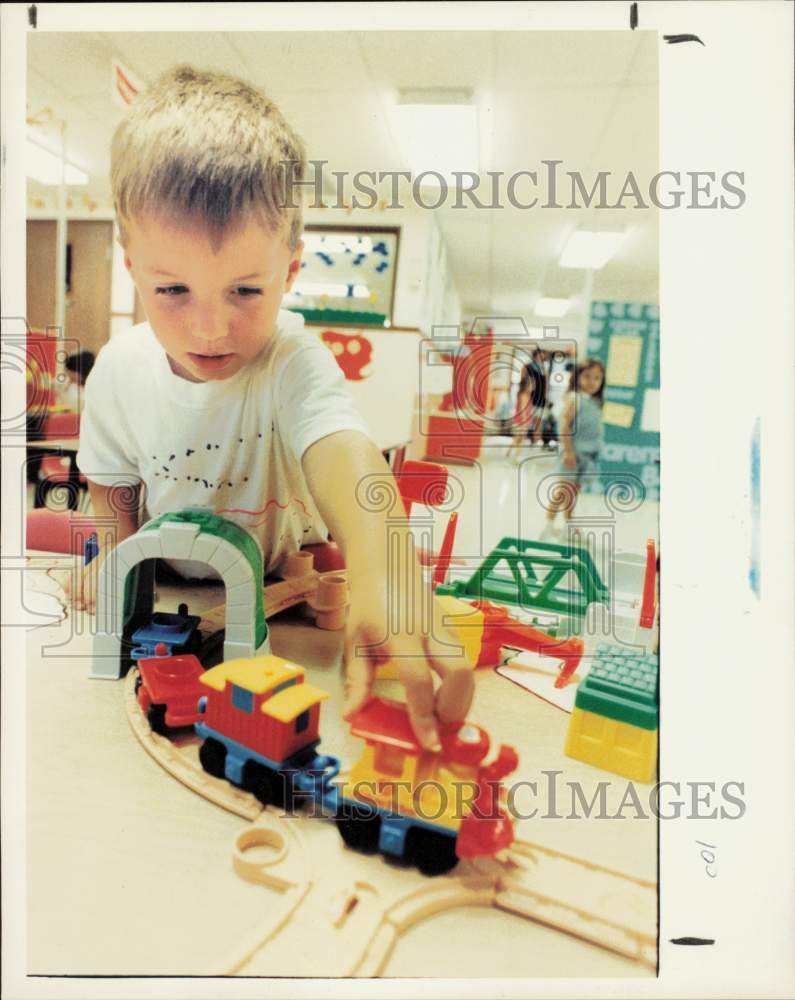 1992 Press Photo Willie Hurley plays with toy train at KinderCare in Michigan- Historic Images