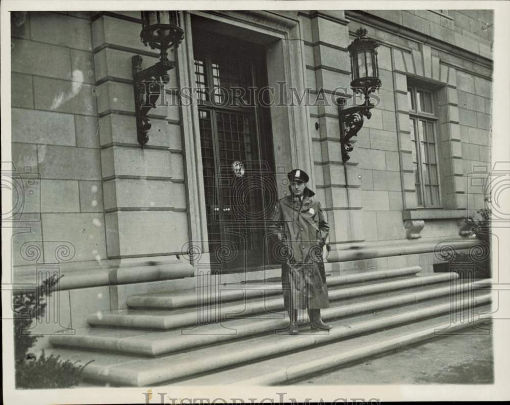 Press Photo Police officer in a trench coat stands outside building - lra97131- Historic Images