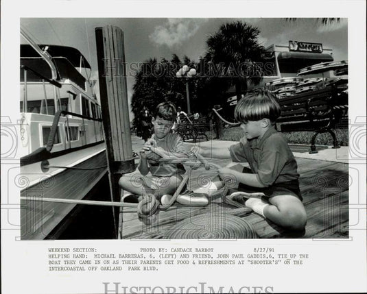 1991 Press Photo Michael Barreras, John Gaddis tie up their boat at "Shooter's"- Historic Images