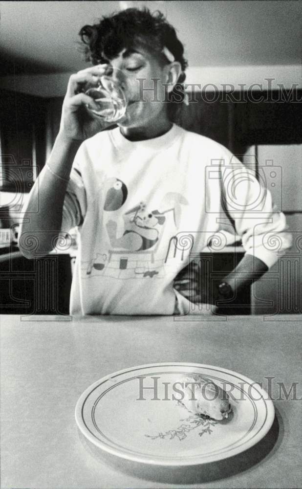 1988 Press Photo Gina Smurro drinking water and eating boiled chicken- Historic Images