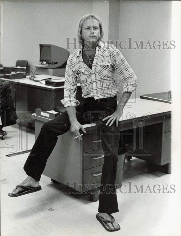 1975 Press Photo An employee wears flip-flops and smokes in Miami office- Historic Images