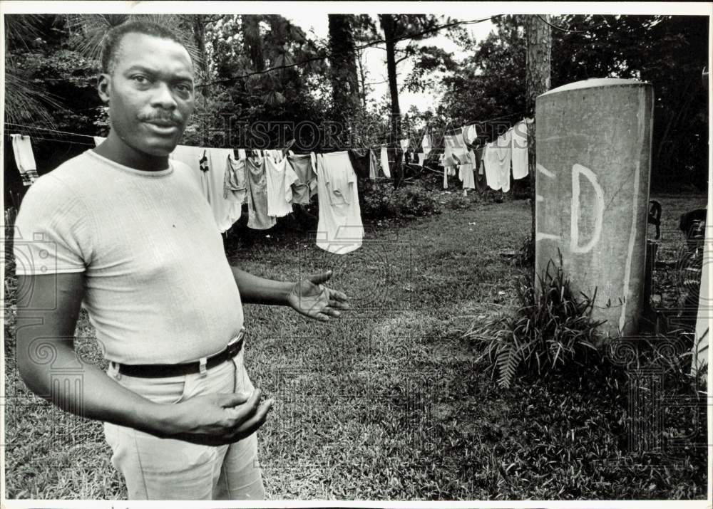 1983 Press Photo Ernest Brown stands beside leaking water tank at his home- Historic Images