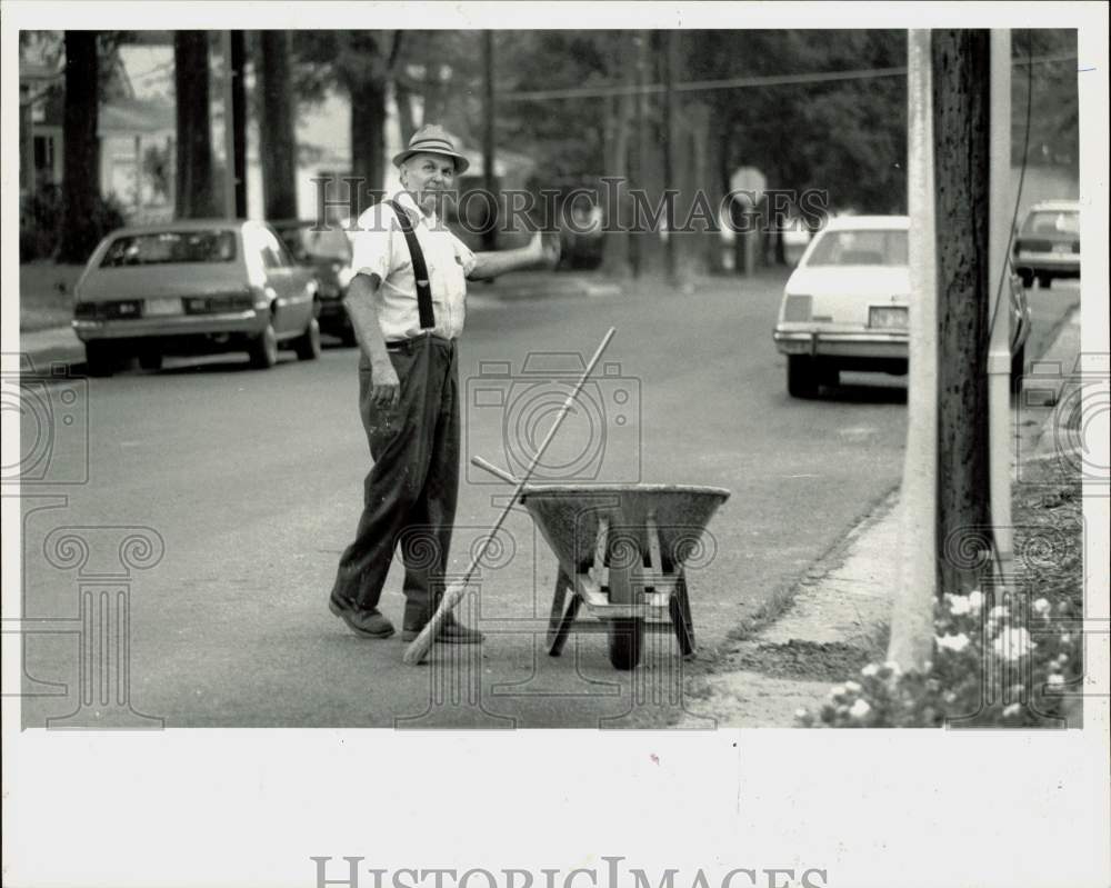 1989 Press Photo J.W. Ridenhour carries off dirt from the sidewalk he removed- Historic Images