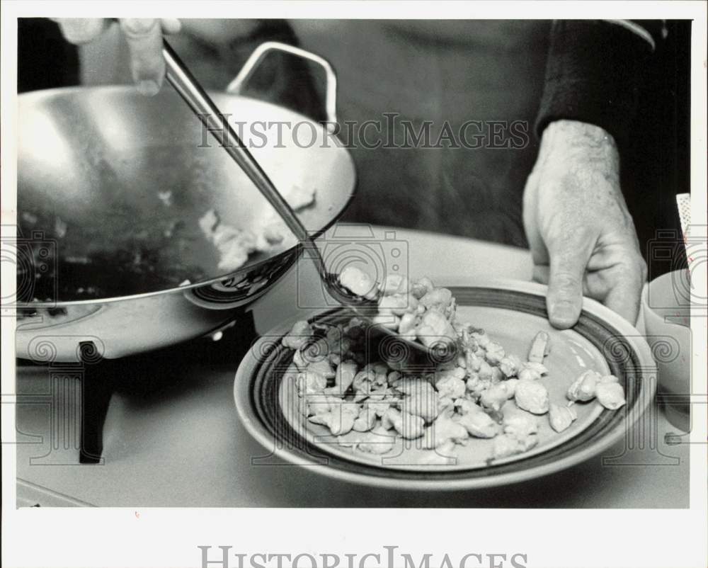 1983 Press Photo Percy Walters removes chicken from pan before veggie stir fry- Historic Images