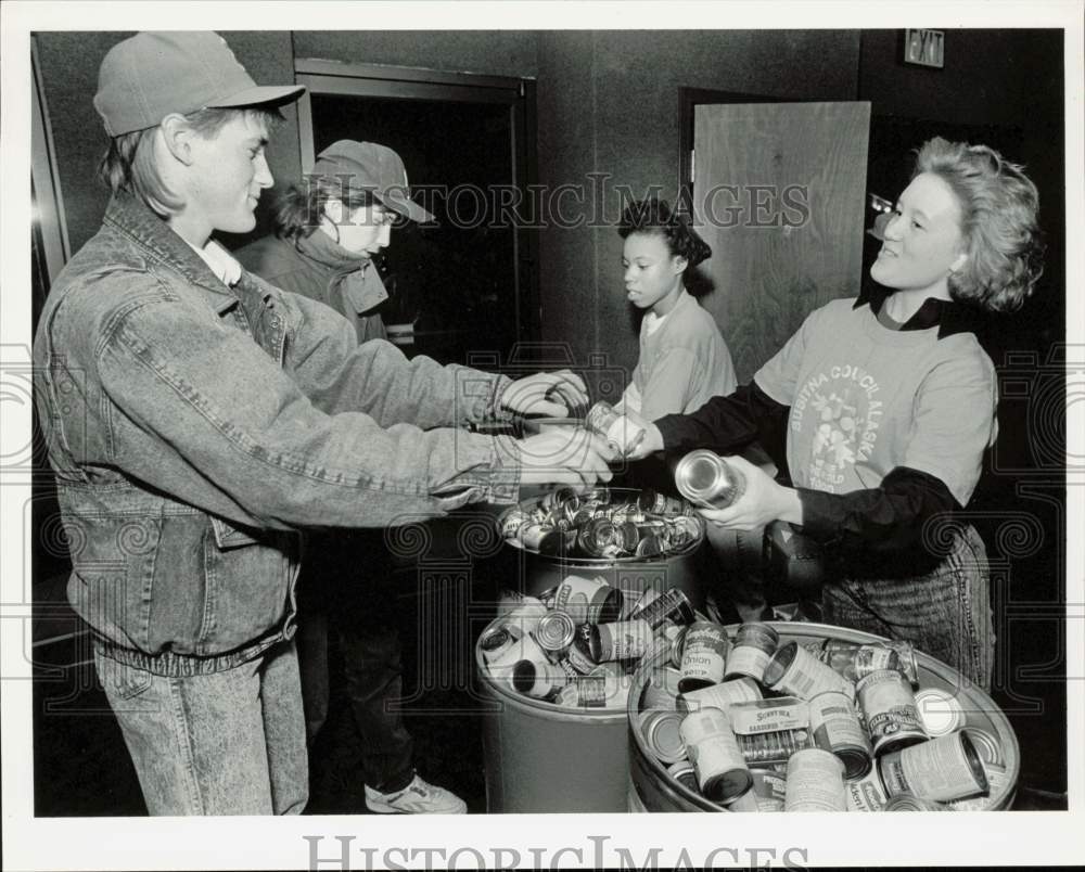 1990 Press Photo Men present cans of food to gain admission at Fireweed Cinemas- Historic Images