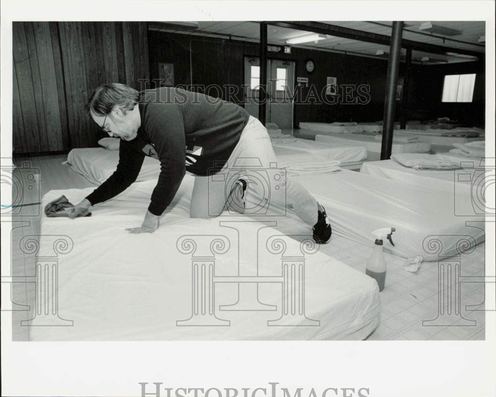 1989 Press Photo Pete Lundheim disinfects bed at Salvation Army Sleep Off Center- Historic Images