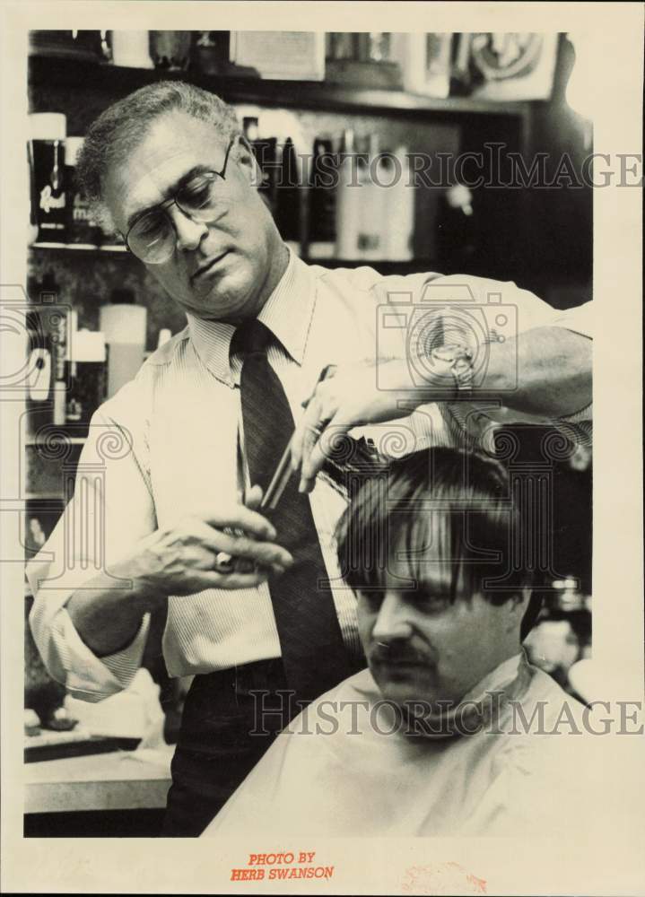 1986 Press Photo Barber Manuel Norat giving customer a haircut, Alaska- Historic Images