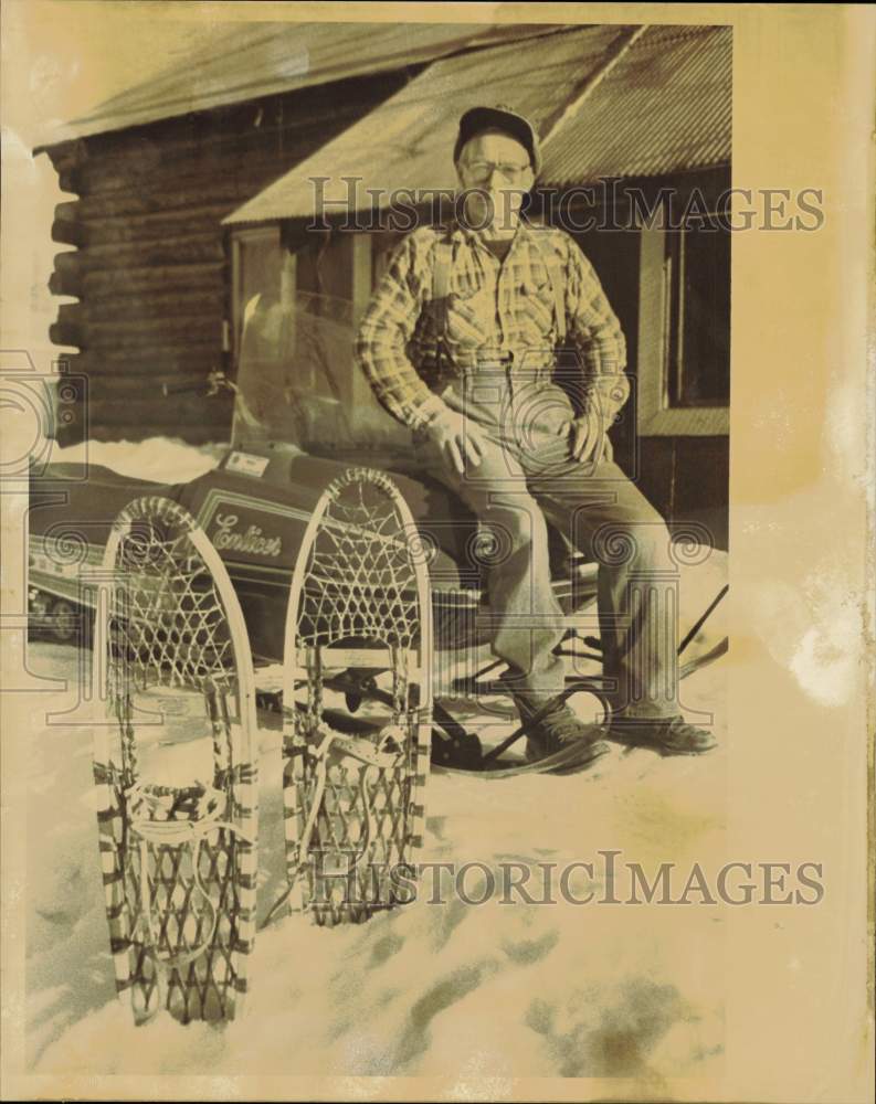 1986 Press Photo Amos Turner with Snowmobile and Snowshoes at Cabin in Alaska- Historic Images