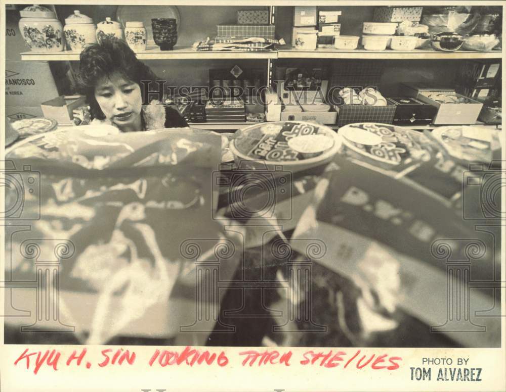 Press Photo Kyu H. Sin looking thru shelves at the store - lrb22557- Historic Images