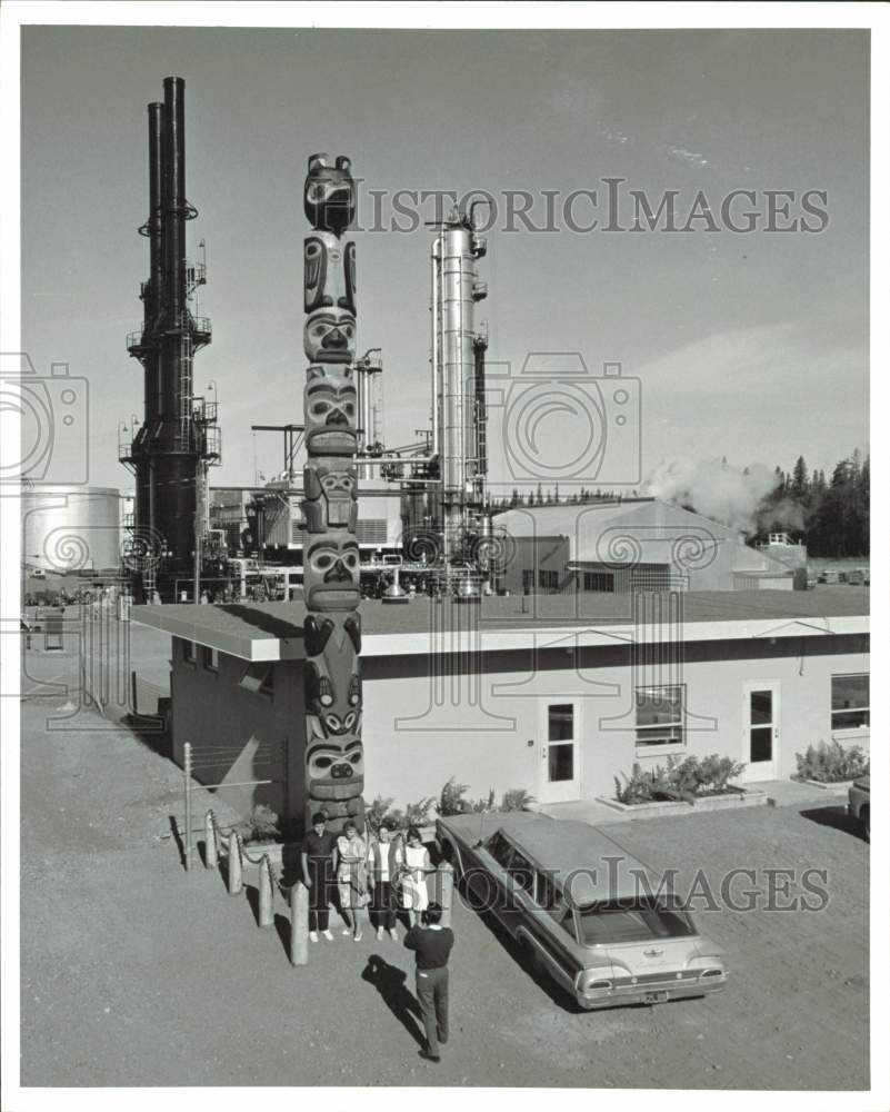 1963 Press Photo Visitors pose with totem pole at Kenai Refinery plant, Alaska- Historic Images