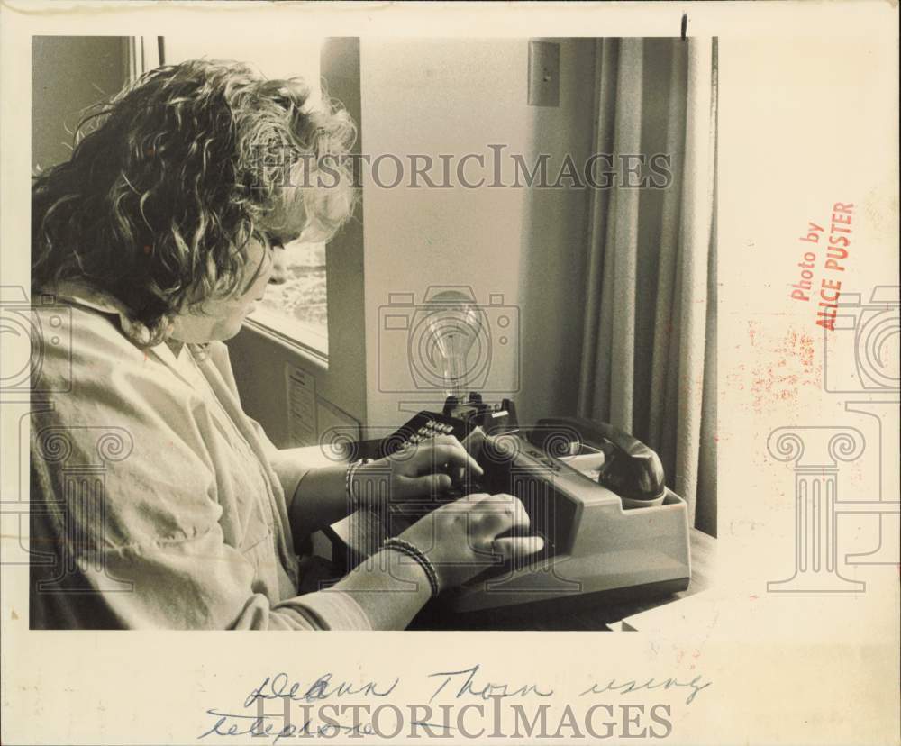 1987 Press Photo Deann Thorn using a telephone for the hearing impaired, Alaska- Historic Images