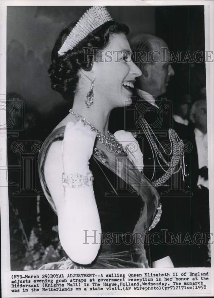 1958 Press Photo Queen Elizabeth II adjusts gown straps at The Hague reception.- Historic Images