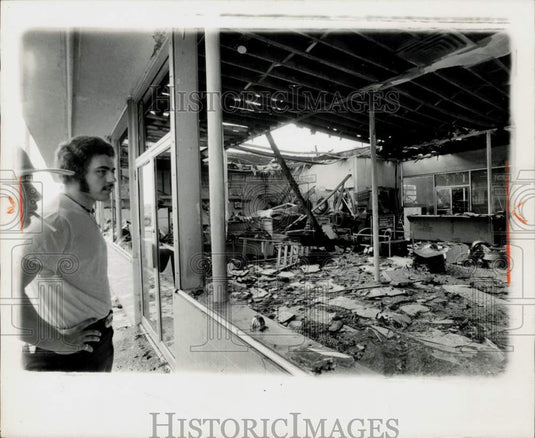 Press Photo Man surveys fire damage to Firestone Tire Company in Vero Beach- Historic Images