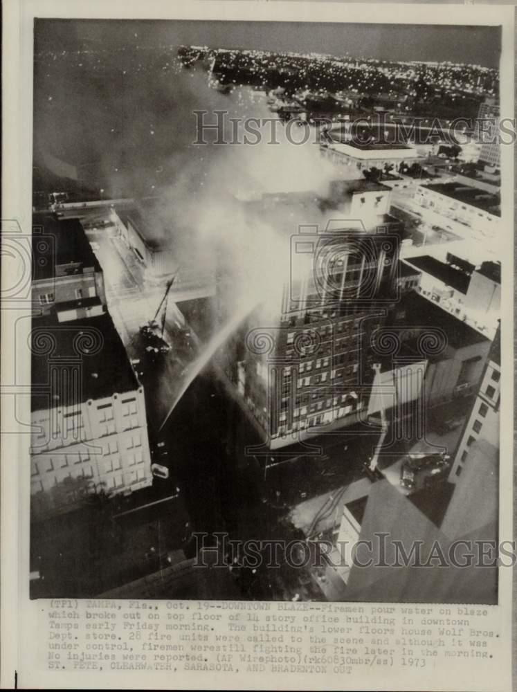 1973 Press Photo Fireman pour water on office building on fire in downtown Tampa- Historic Images