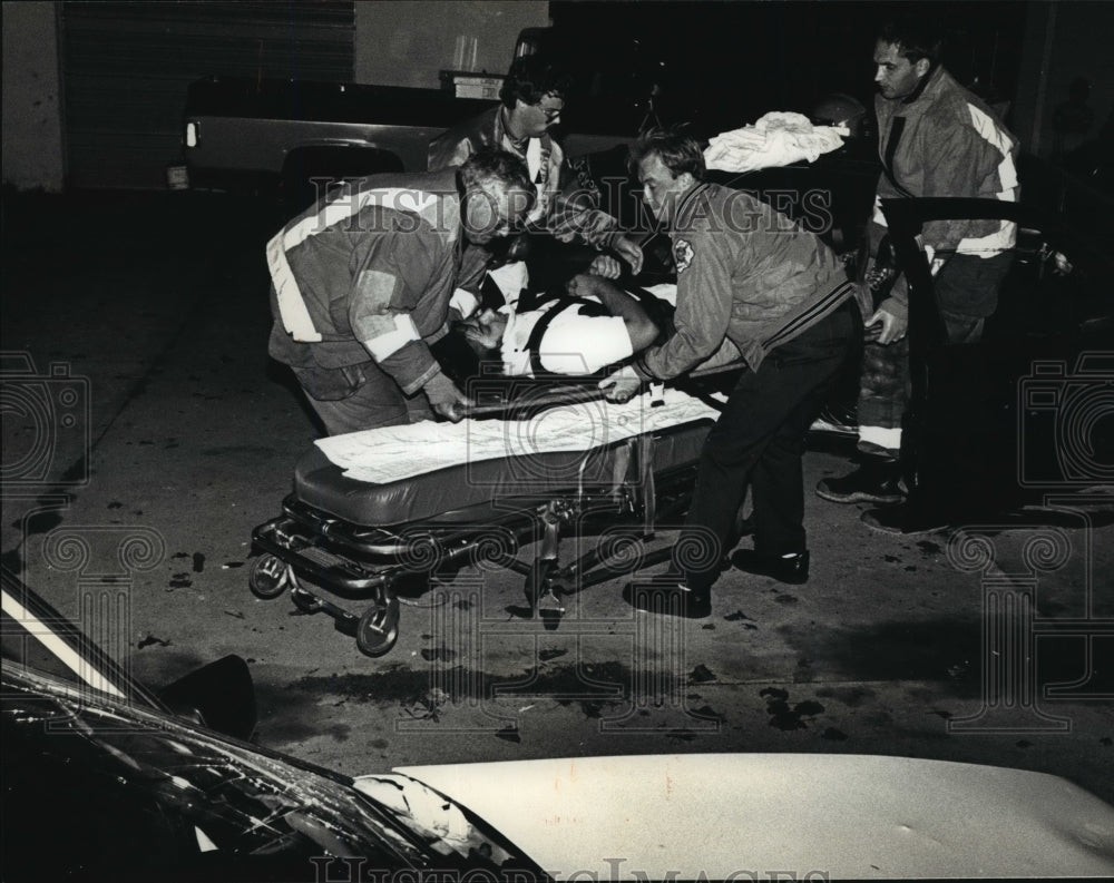 1990 Press Photo Firemen tend injured man from speed chase crash in Waukesha- Historic Images