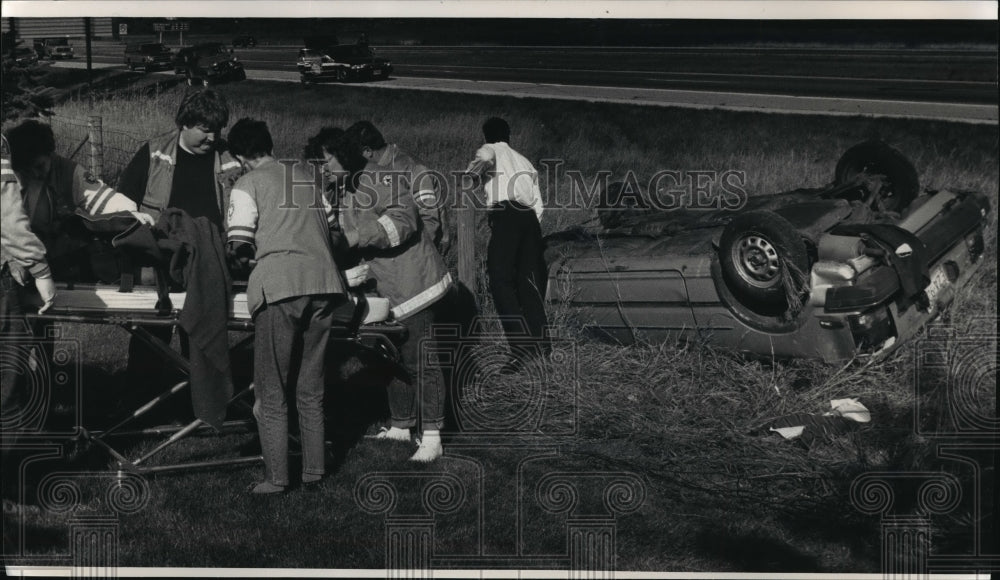 1992 Press Photo Rescue personnel on scene of car accident overturned on I-43 - Historic Images