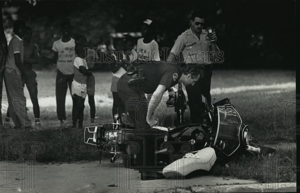 1989 Press Photo Police officers examine motorcycle crash on N 30th &amp; W Hadley - Historic Images