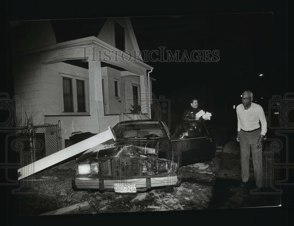 1990 Press Photo Lloyd Robinson examine the car crash on neighbors&#39; home- Historic Images