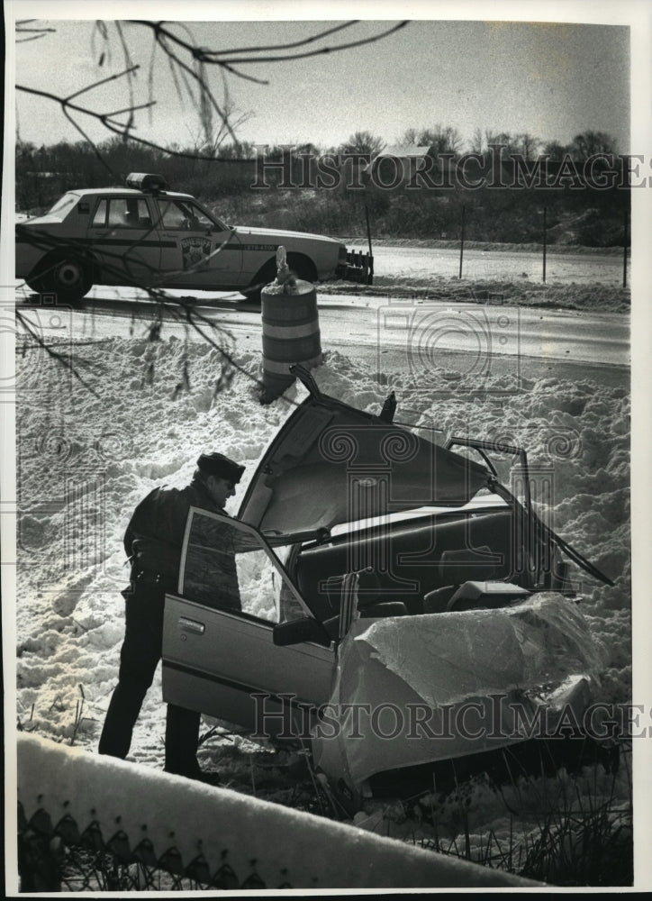 1991 Press Photo Wreckage of a car on Interstate 43 inspect by police officer- Historic Images