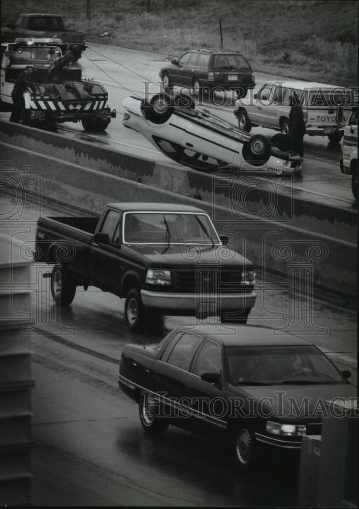 1995 Press Photo A tow truck operator works at uprighting a car that rolled over- Historic Images