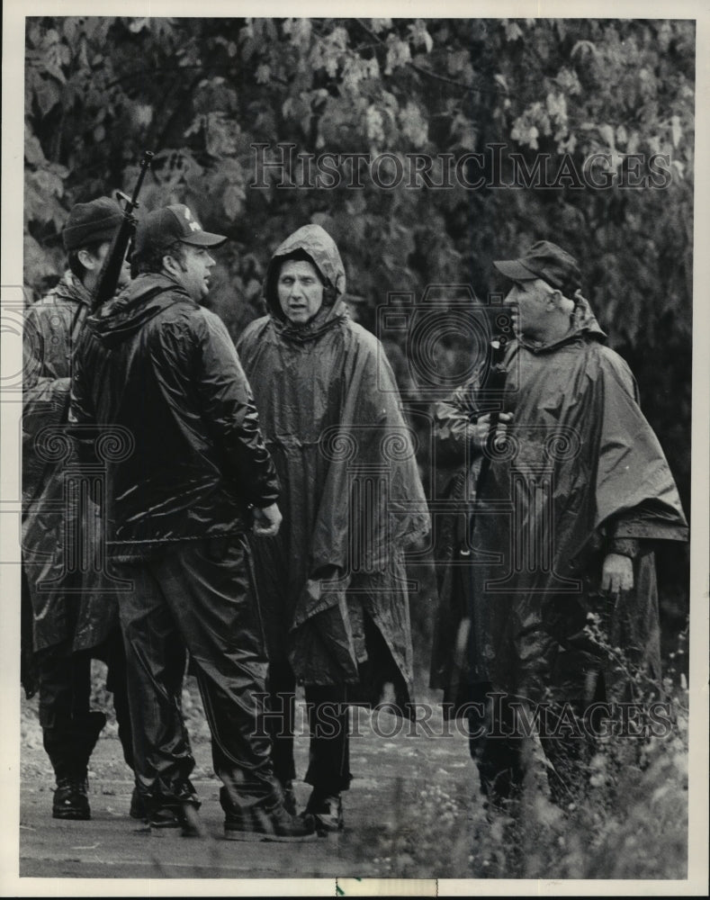 1983 Press Photo Milwaukee policemen trudged through the mud in search - Historic Images