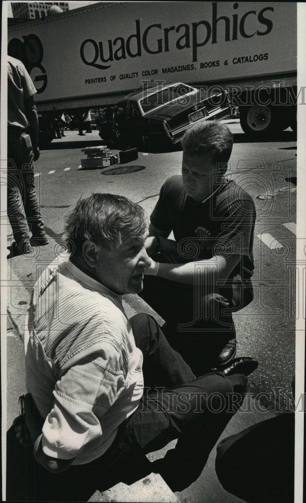 1990 Press Photo Attorney Robert Arieff sits on curb as a Milwaukee firefighter- Historic Images