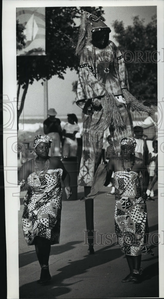 1989 Press Photo Melinda and Melissa Gladney dance around a Chakaba Stilt dancer- Historic Images