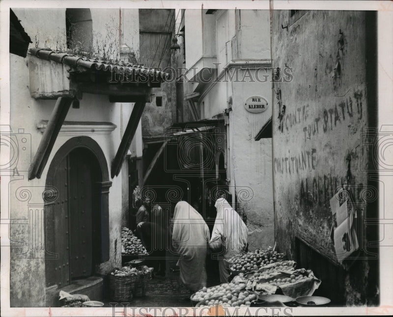 Load image into Gallery viewer, 1955 Press Photo Veiled woman shop for food in the street of Algiers
