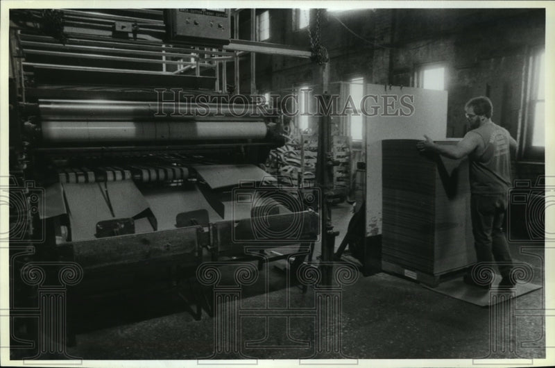 Load image into Gallery viewer, 1968 Press Photo Terry Wiese stacks newly manufactured paperboard - mja06163
