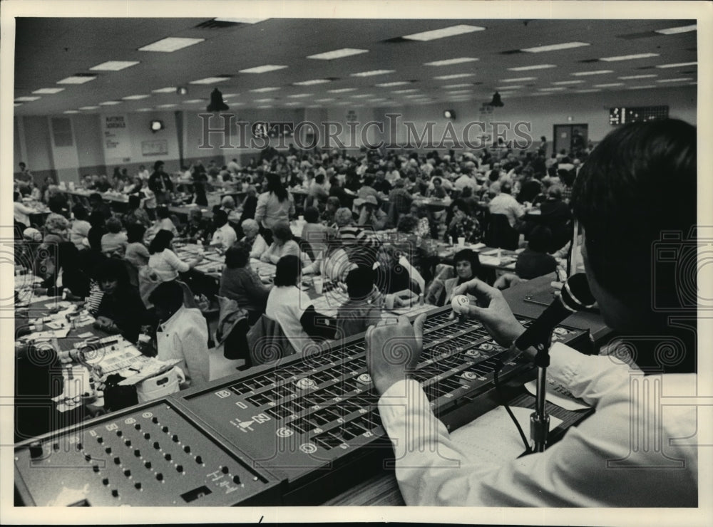 1984 Press Photo The bingo caller announced a number, while keeping track- Historic Images