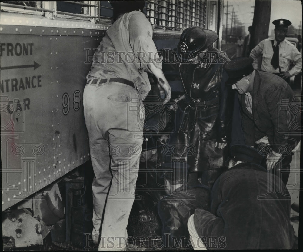 1952 Press Photo Fireman jacking up car to free body of Grace Stengel