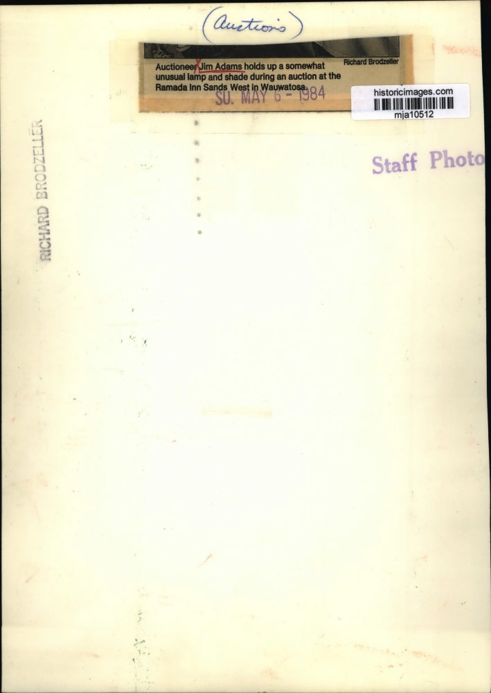 1984 Press Photo Auctioneer Jim Adams holds up a somewhat unusual lamp and shade