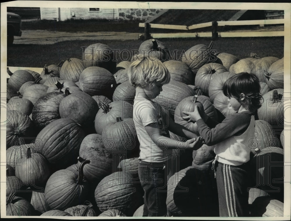 1983 Press Photo Terra Turner handed her brother, John, her choice of pumpkins- Historic Images