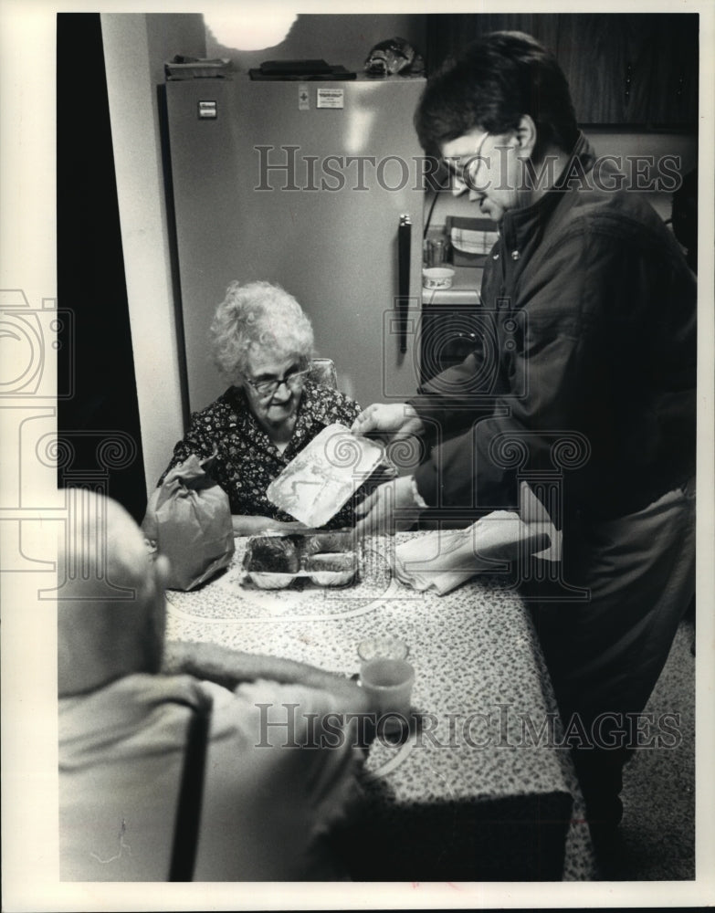 Load image into Gallery viewer, 1989 Press Photo Peg Van Altena serves Matt Diedrich at Waukesha Dept. of Aging
