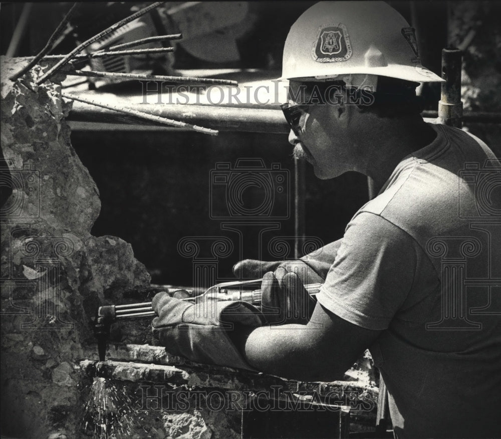 1992 Press Photo Scott Johnson cuts iron rods from the old concrete - mja22126
