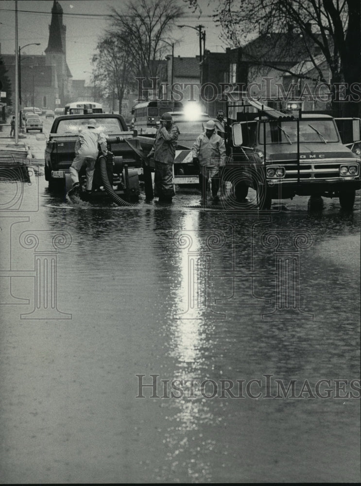 1985 Press Photo Waukesha public works employees pump water off Main Street- Historic Images