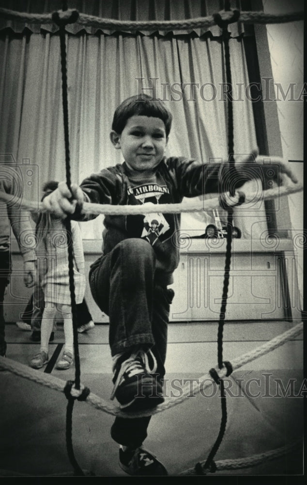 Load image into Gallery viewer, 1987 Press Photo Jeremy Webster climbs a rope ladder at Whitman Middle School.
