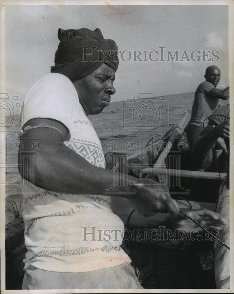 1956 Press Photo Native fisherman in Kenya hauls turtles attached to fish&#39;s tail- Historic Images