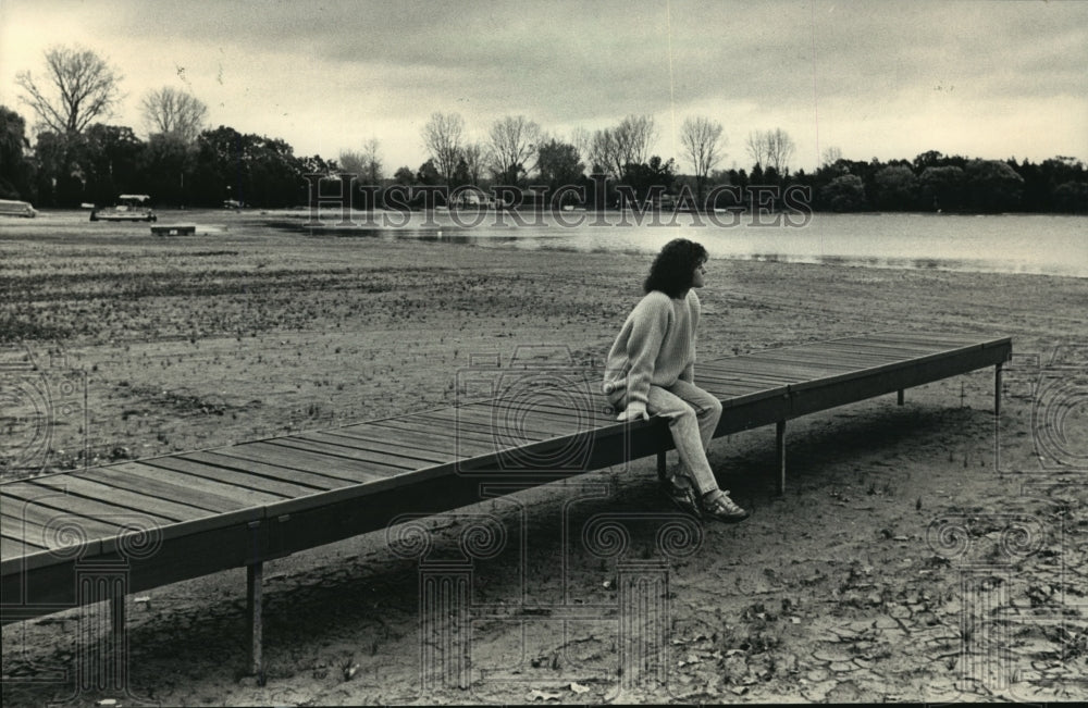 1987 Press Photo Faith Lundy sitting on dried up dock by Pretty Lake - mja35955- Historic Images